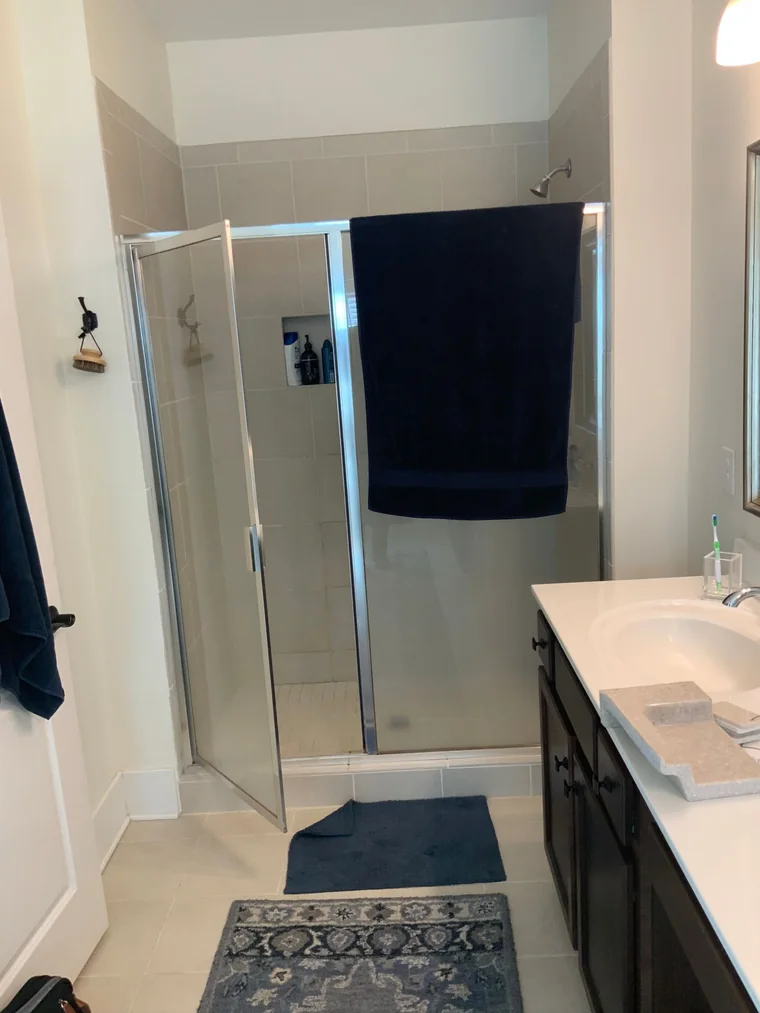 Framed shower enclosure with dated panels before the upgrade